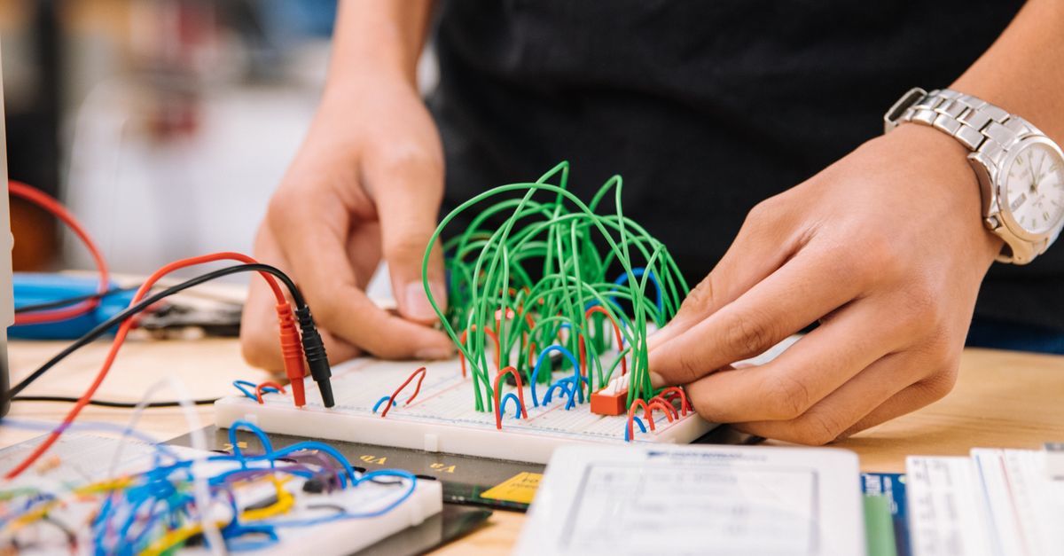 Plaque d'essai avec fils colores et petit module electronique pose sur un plan de travail